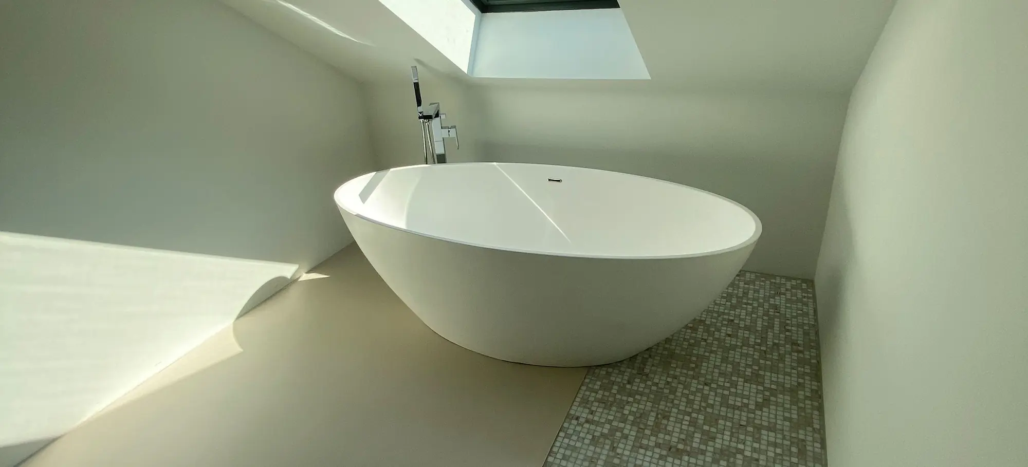 Dachgeschossbad mit freistehender Wanne und Mosaikband