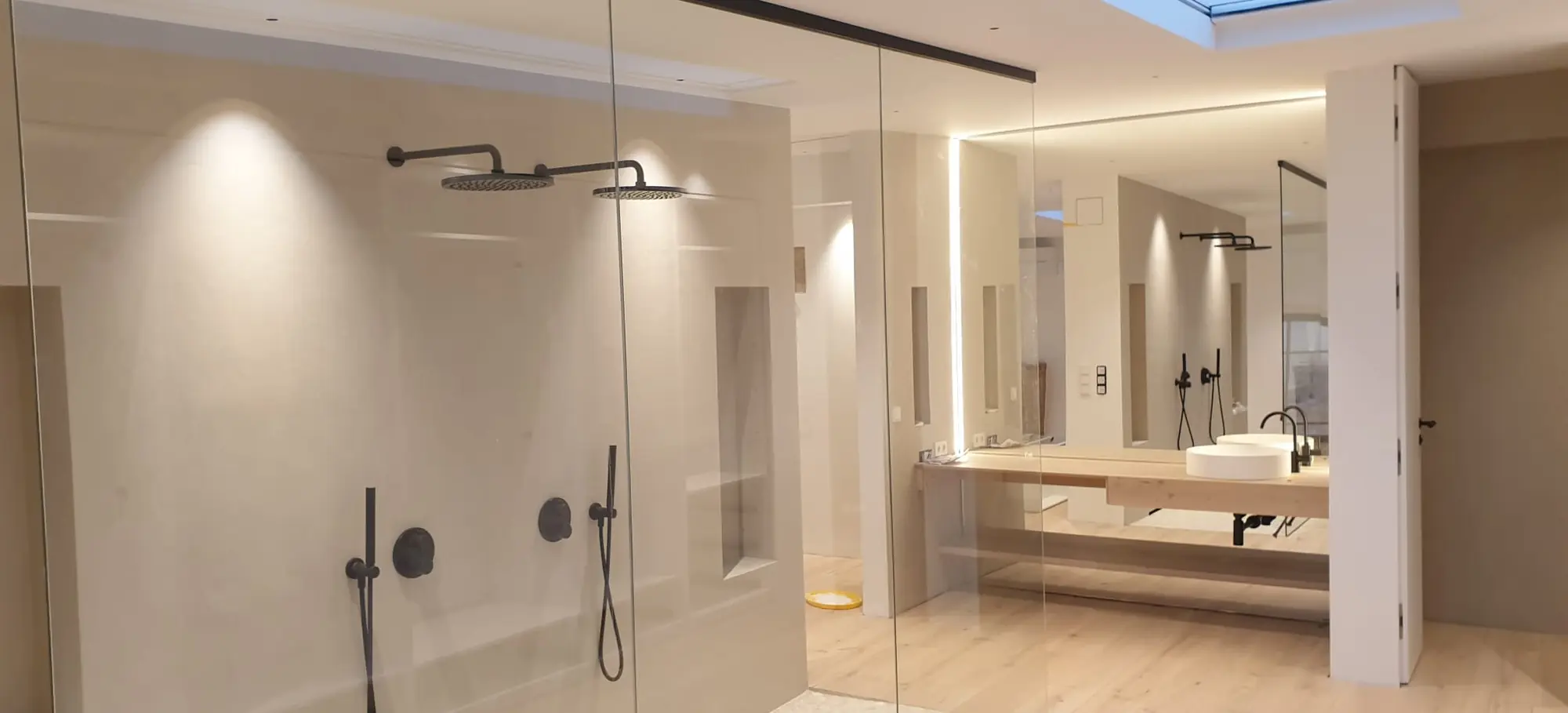 Bad mit bodengleicher Dusche, Wandnischen und indirekter Beleuchtung
