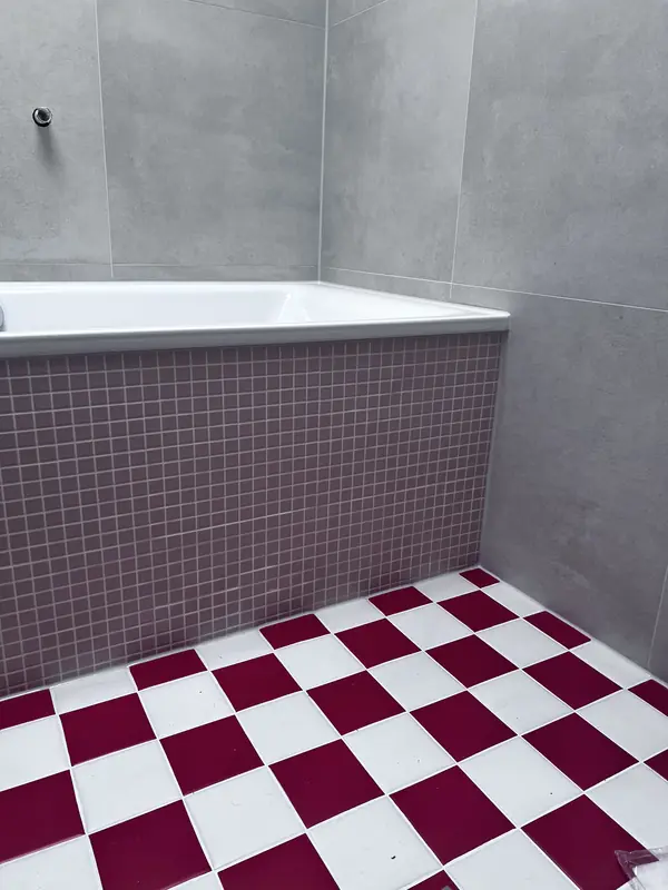 Wannenverkleidung aus Mosaikfliesen, großformatige Wandfliesen und Schachbrettboden